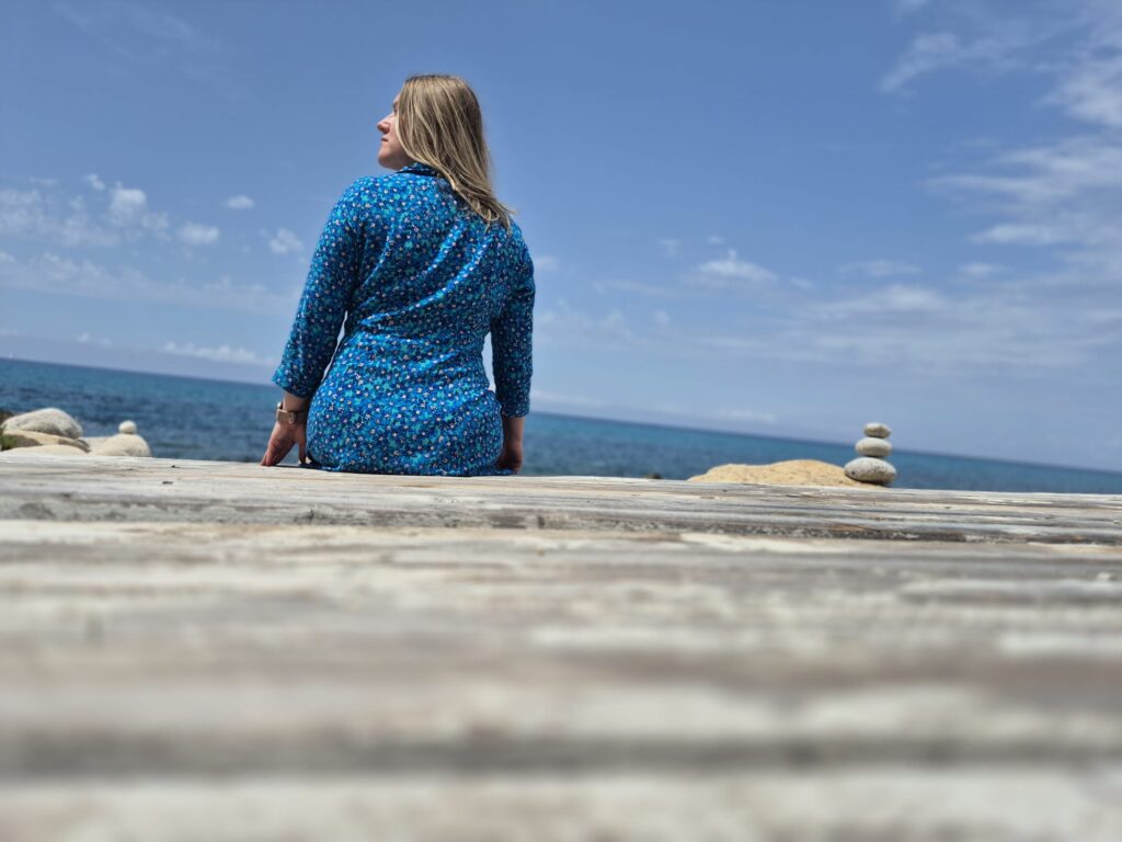 Frau sitzt am Wasser als Symbol dafür, dass echte Veränderung tiefer im Nervensystem beginnt